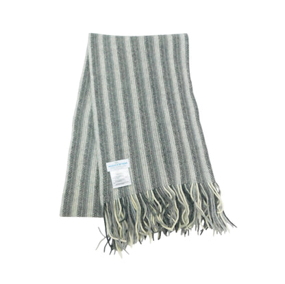 A striped knit scarf in muted gray, sage green, and cream with fringed ends and a small sewn-in label, shown on a plain white background.